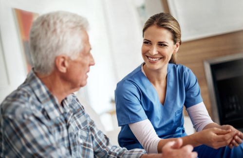 Shot of a female nurse and her senior patient chatting in the living room